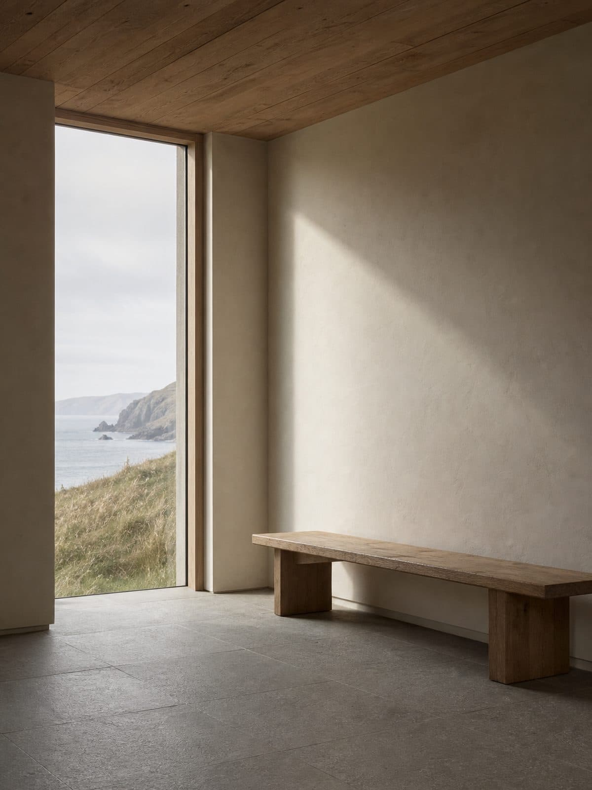 A calm interior of oiled oak, lime plaster and honed granite, lit by a single tall opening.